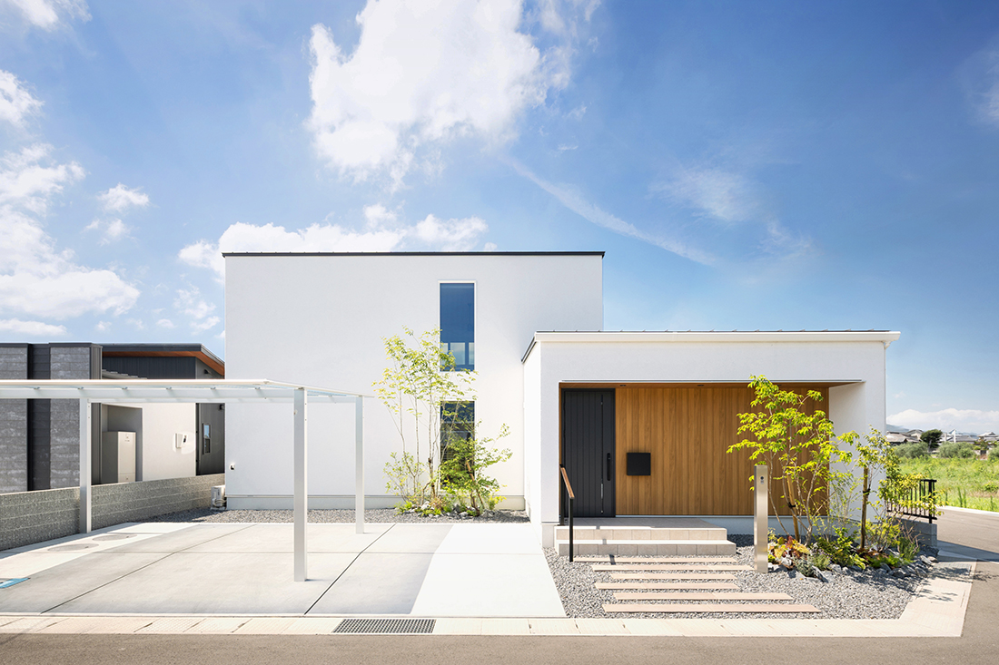 ホワイトの吹付塗装に木目が映えるモダンな2階建て