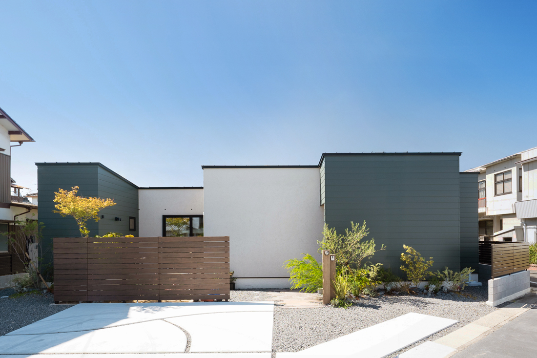 白の吹付塗装とグリーンのガルバリウムを使った平屋