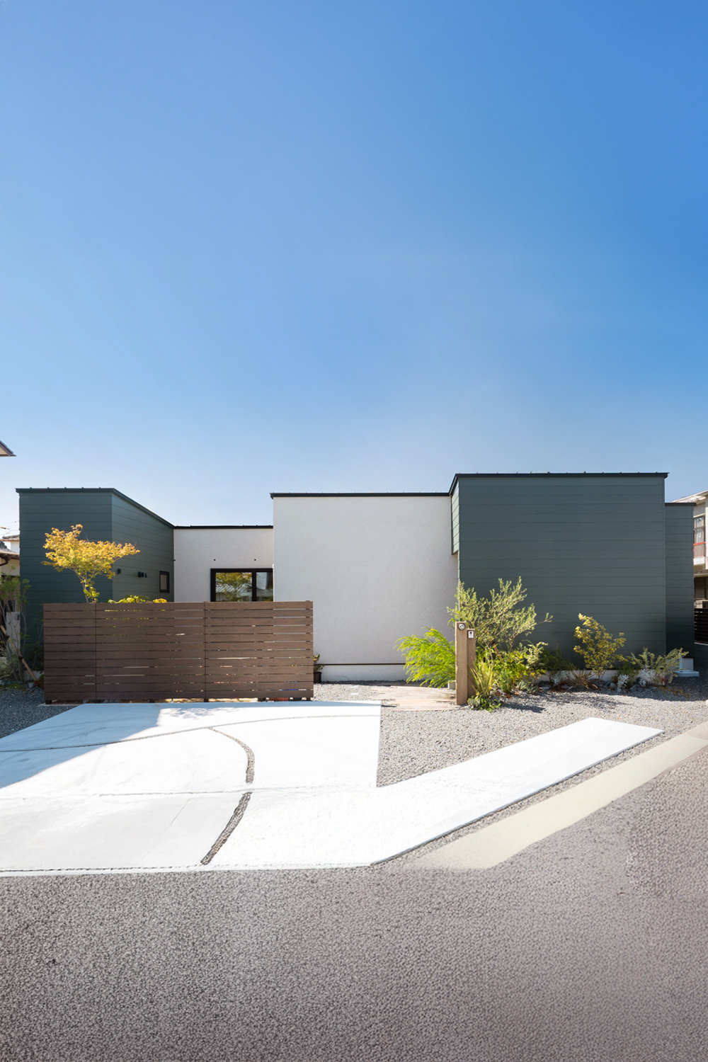 白の吹付塗装とグリーンのガルバリウムを使った平屋