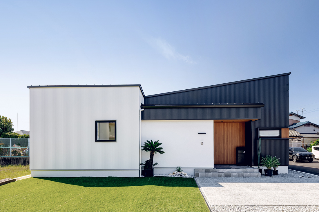 白の吹付塗装・黒のガルバリウム・木目のサイディングを組み合わせた平屋の外観