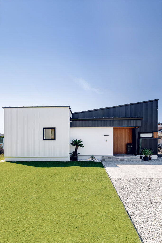 白の吹付塗装・黒のガルバリウム・木目のサイディングを組み合わせた平屋の外観