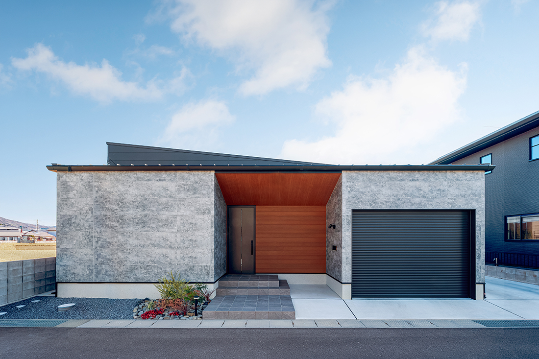 木目×石目の外壁のガレージのある平屋
