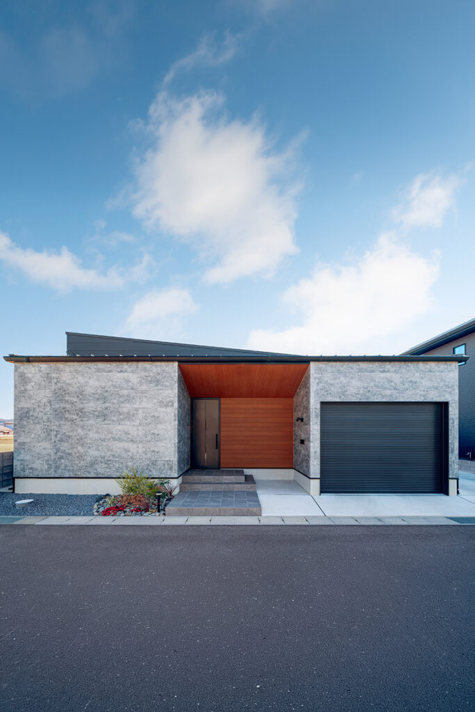 木目×石目の外壁のガレージのある平屋